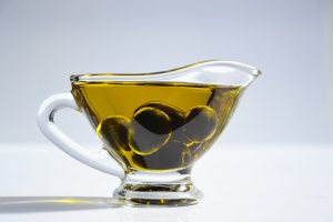 green olives in a cup of olive oil